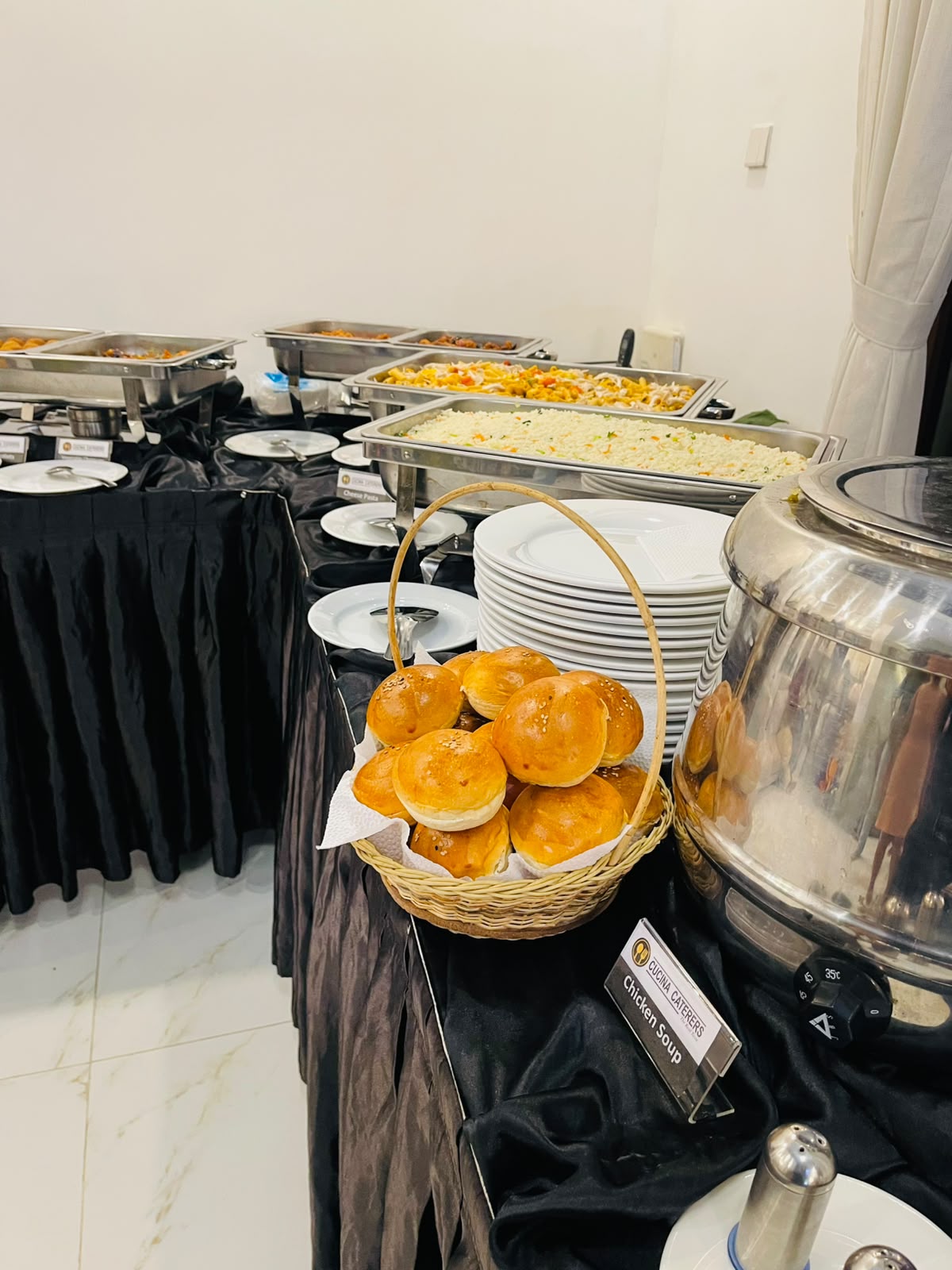Buffet spread with chafing dishes and fresh buns by Cucina Caterers