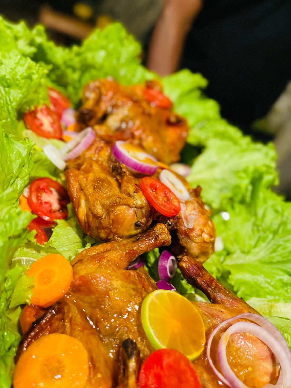 Roast chicken platter garnished with fresh vegetables
